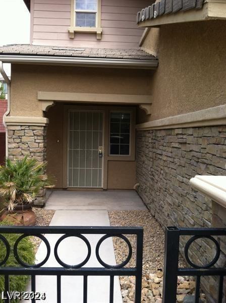 property entrance with stone siding and stucco siding