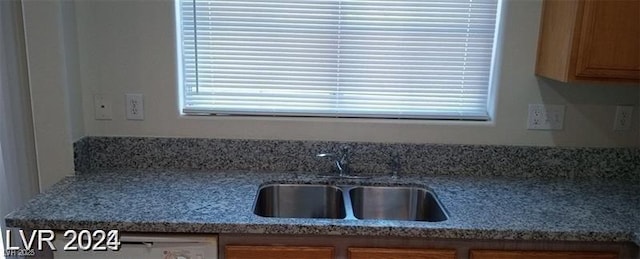 kitchen featuring light countertops, a sink, and brown cabinets