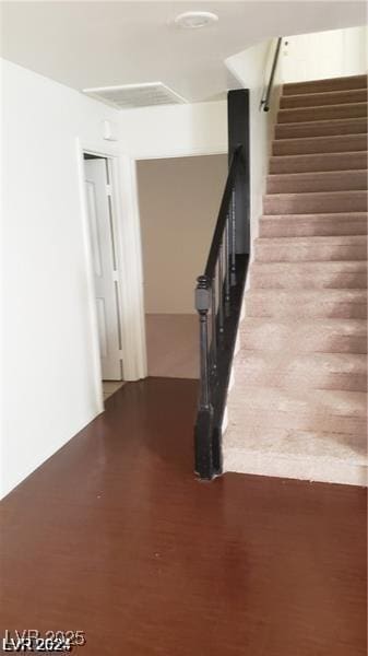 stairs featuring wood finished floors