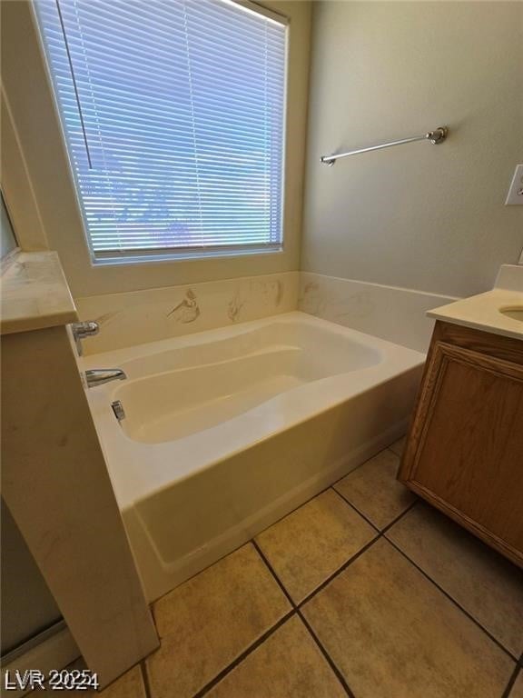 full bathroom featuring vanity, a bath, and tile patterned floors