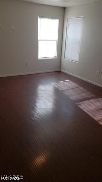 unfurnished room featuring baseboards and wood finished floors