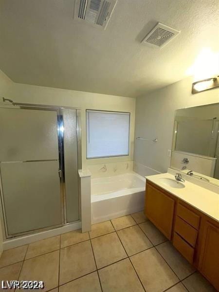 bathroom featuring a bath, double vanity, visible vents, and tile patterned floors