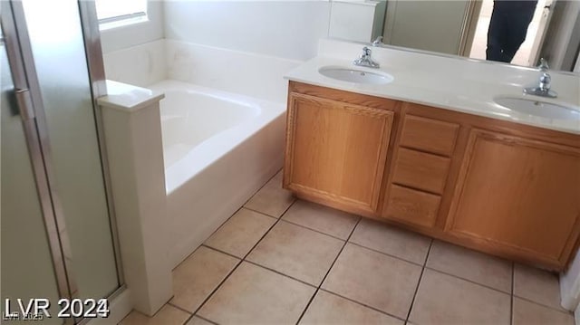 full bath with tile patterned flooring, a garden tub, a sink, and double vanity