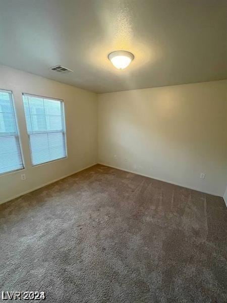 unfurnished room with carpet and visible vents