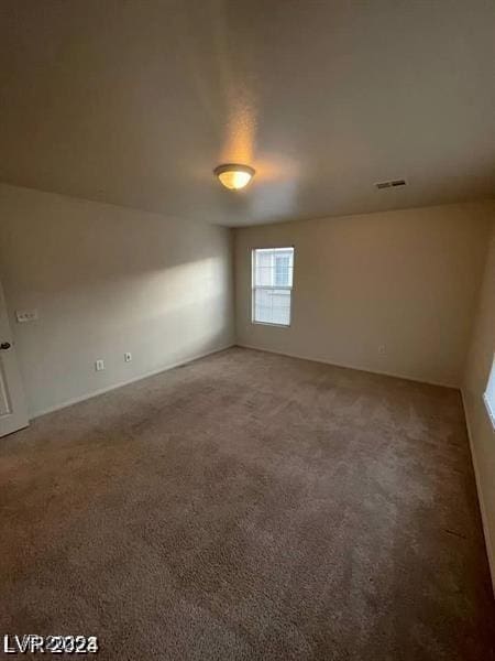 carpeted spare room featuring visible vents