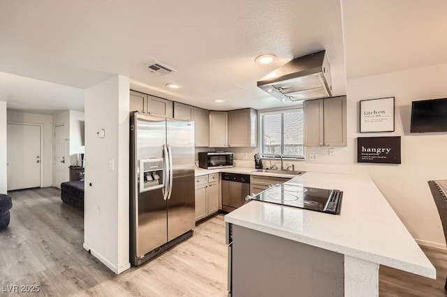 kitchen with light countertops, appliances with stainless steel finishes, a peninsula, and visible vents