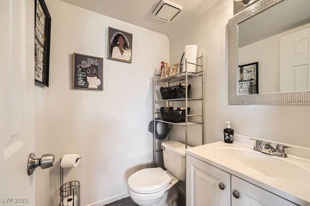 half bath featuring visible vents, vanity, and toilet