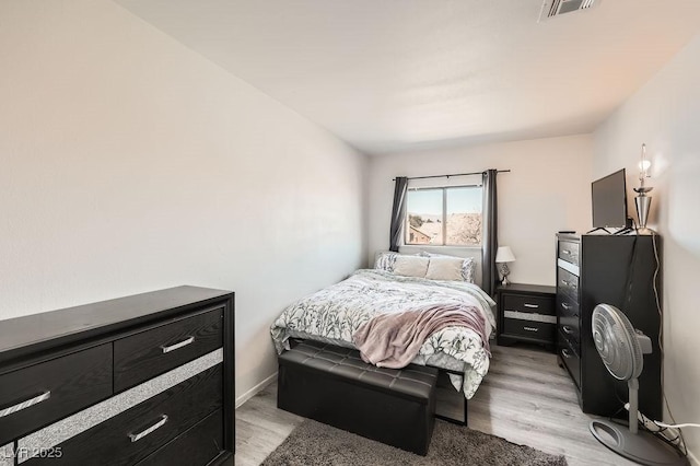 bedroom with light wood-style floors and visible vents