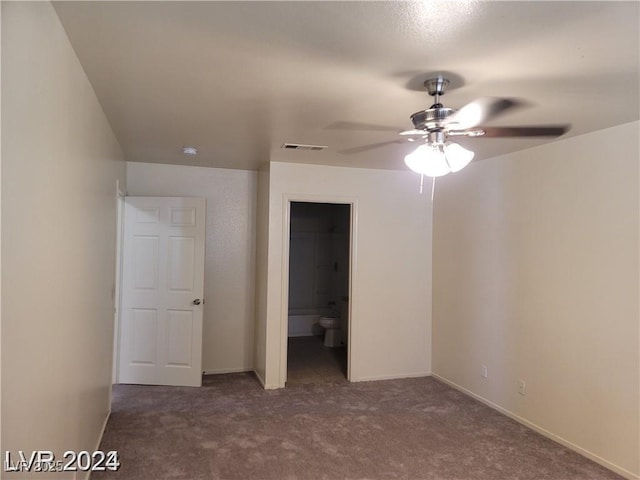 unfurnished bedroom featuring dark colored carpet, visible vents, and baseboards