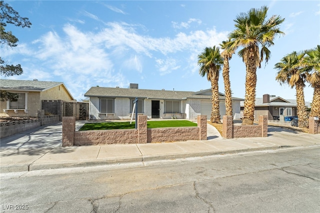 view of front of house featuring a front yard, an attached garage, fence, and driveway