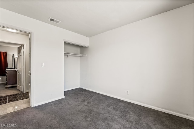 unfurnished bedroom featuring visible vents, carpet floors, baseboards, and a closet