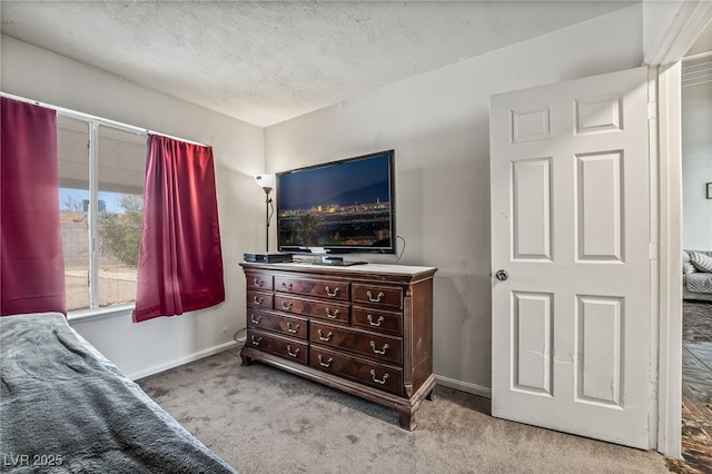 bedroom featuring carpet, baseboards, and a textured ceiling