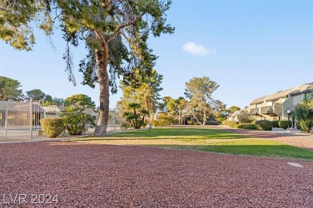 view of home's community with a lawn and fence