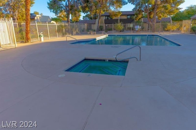 community pool with a community hot tub, fence, and a patio