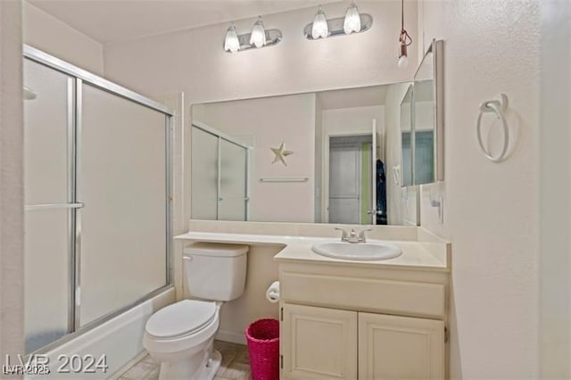 bathroom featuring toilet, shower / bath combination with glass door, and vanity