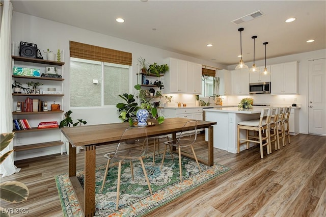 dining room with light wood-style flooring, visible vents, and recessed lighting