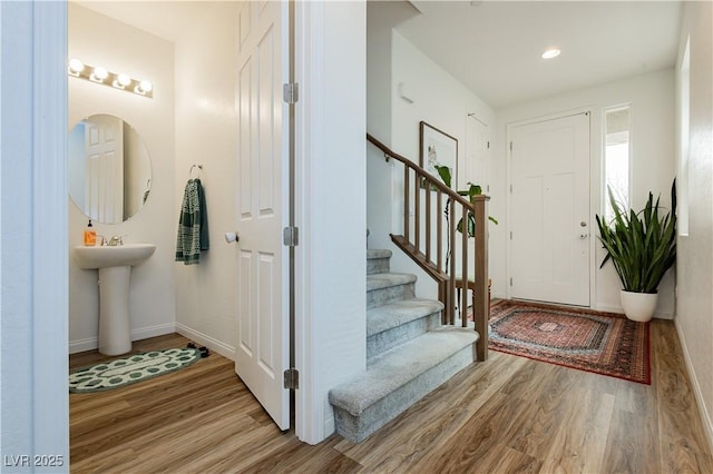 foyer entrance featuring light wood-style floors, recessed lighting, baseboards, and stairs