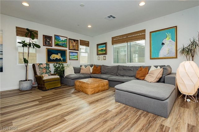 living room featuring light wood-type flooring, visible vents, and recessed lighting