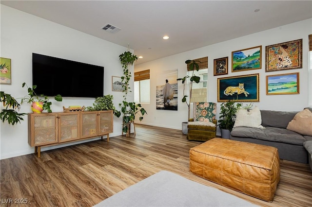 living area featuring recessed lighting, visible vents, baseboards, and wood finished floors