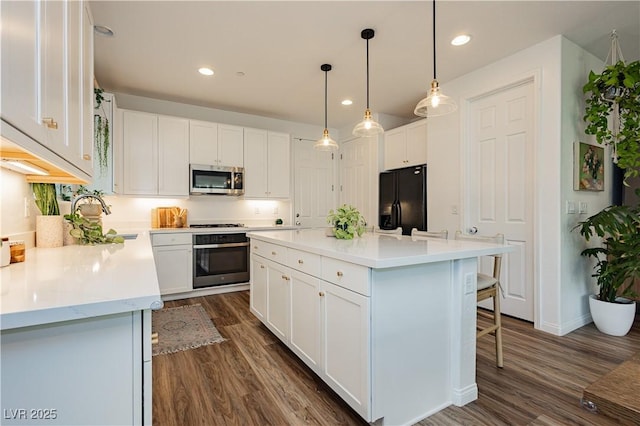 kitchen featuring appliances with stainless steel finishes, white cabinets, light countertops, and a sink