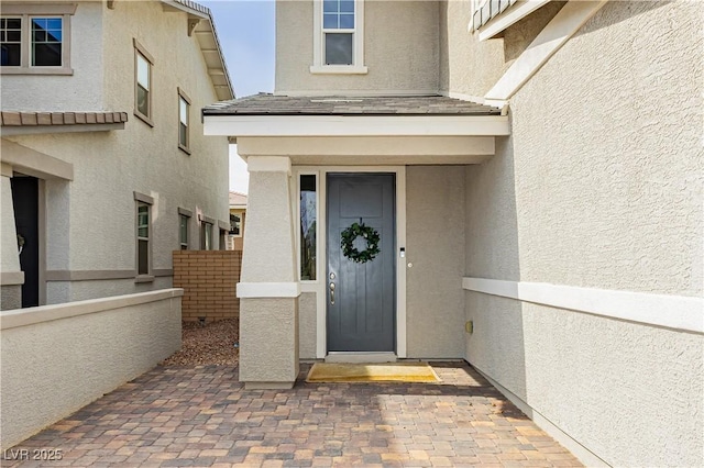 property entrance with fence and stucco siding