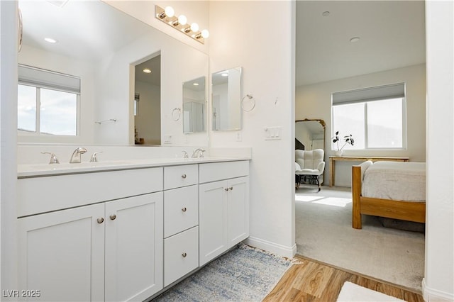 full bath with a wealth of natural light, a sink, and ensuite bath