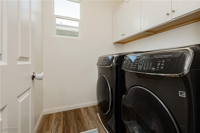 washroom featuring cabinet space, baseboards, dark wood-style floors, and washer and clothes dryer