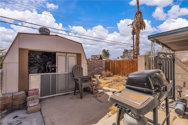 view of patio featuring an outbuilding, a fenced backyard, and grilling area