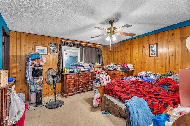 bedroom with a ceiling fan, a textured ceiling, and carpet flooring