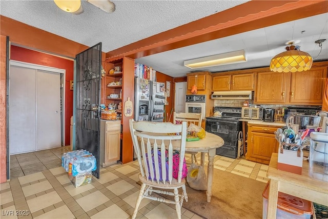 kitchen with tasteful backsplash, under cabinet range hood, brown cabinets, stainless steel appliances, and a textured ceiling