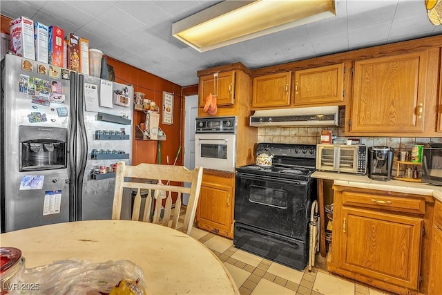 kitchen with oven, stainless steel refrigerator with ice dispenser, black electric range oven, under cabinet range hood, and light countertops