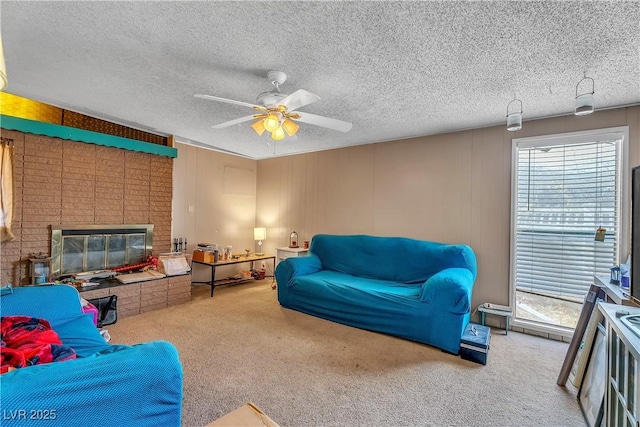 carpeted living area featuring a ceiling fan, a textured ceiling, and a fireplace