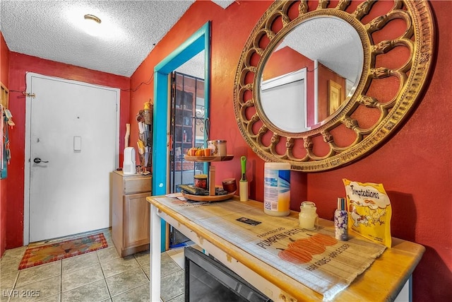 foyer entrance featuring light tile patterned floors and a textured ceiling