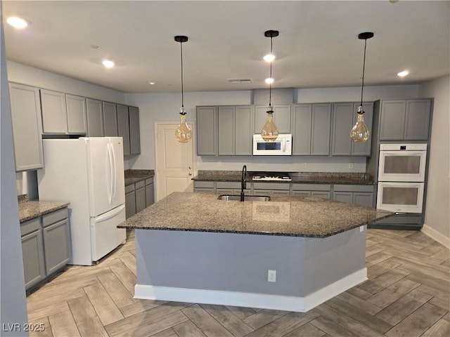 981 Soaring Moon Dr, Henderson, NV 89015 - kitchen featuring a sink, white appliances, gray cabinets, dark stone counters, and recessed lighting