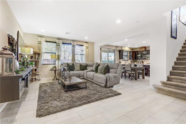 living area featuring recessed lighting, visible vents, plenty of natural light, and stairway