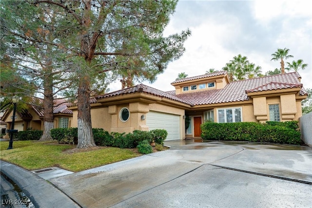 mediterranean / spanish-style house featuring a garage, a tile roof, concrete driveway, and stucco siding