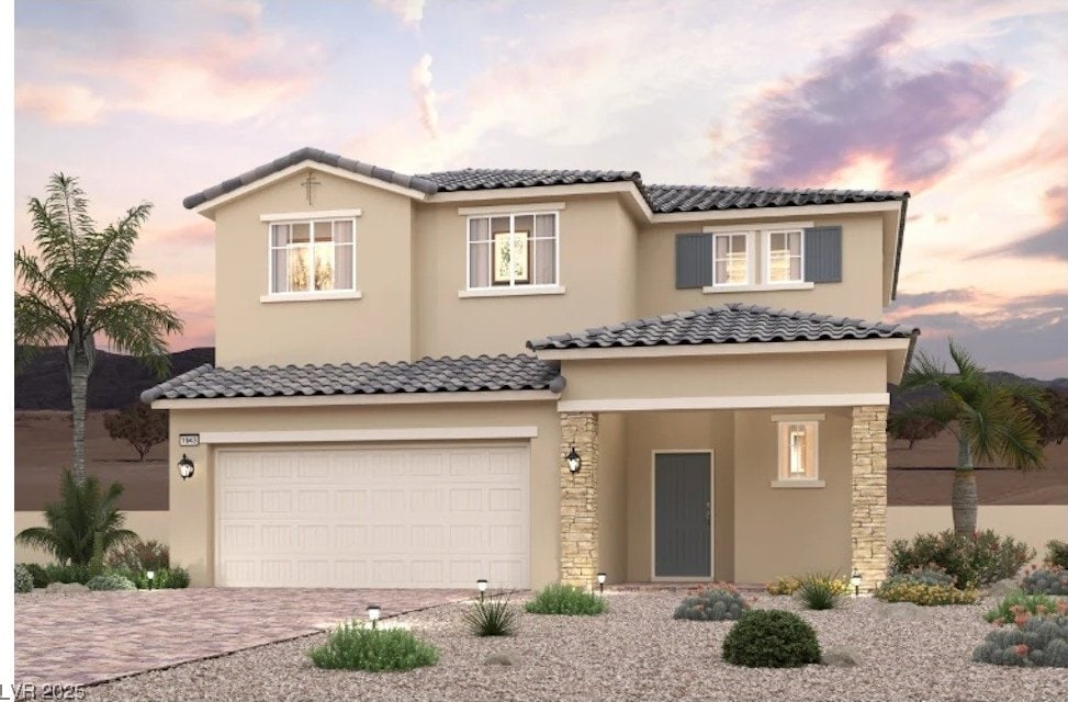 view of front of property featuring a garage, decorative driveway, a tile roof, and stucco siding