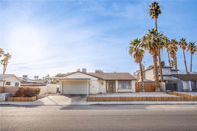 single story home with a garage, driveway, and fence