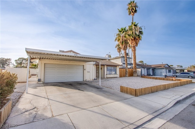 ranch-style home with an attached garage, fence, and concrete driveway