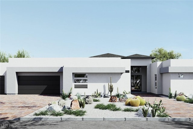 contemporary home featuring decorative driveway, an attached garage, and stucco siding