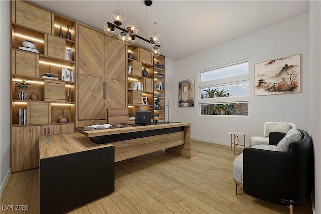 home office with baseboards and light wood finished floors