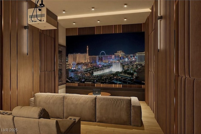 cinema room featuring light wood-type flooring and wooden walls