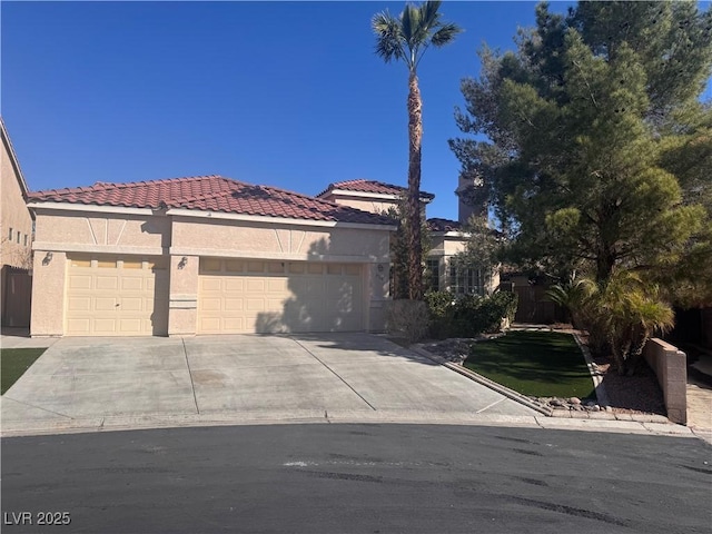 mediterranean / spanish-style home featuring an attached garage, driveway, a tile roof, and stucco siding