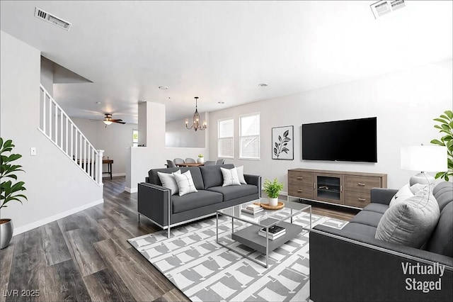 living room featuring visible vents, stairway, baseboards, and wood finished floors