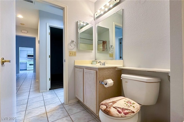 bathroom featuring vanity, tile patterned flooring, and toilet