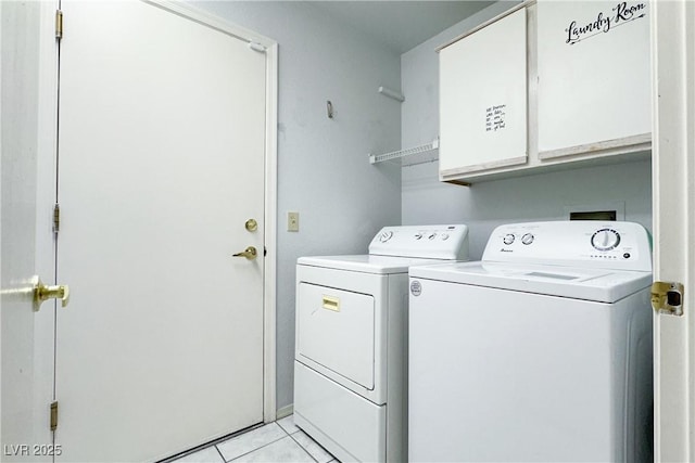 clothes washing area with cabinet space, washer and dryer, and light tile patterned flooring