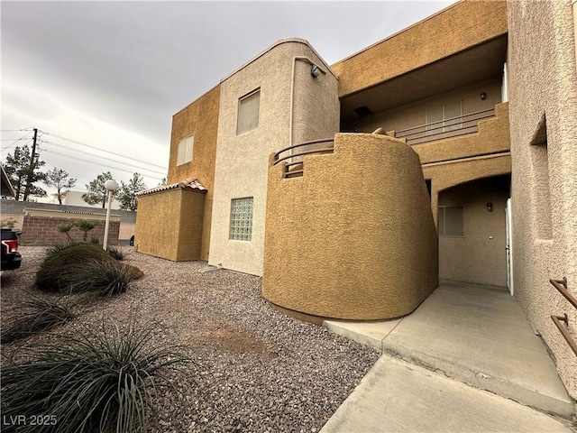 view of home's exterior featuring fence, a patio, and stucco siding