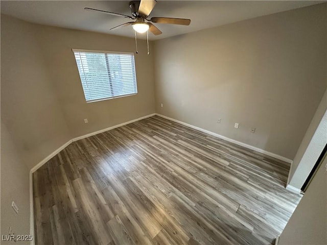 spare room featuring a ceiling fan, baseboards, and wood finished floors