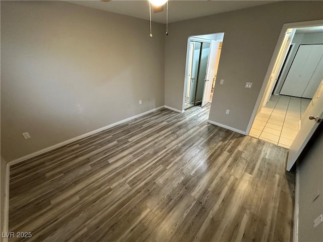 unfurnished bedroom featuring dark wood-style floors and baseboards