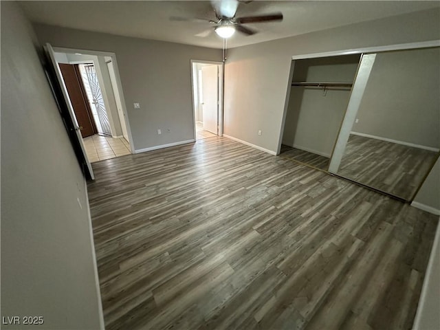 unfurnished bedroom with a ceiling fan, a closet, baseboards, and wood finished floors